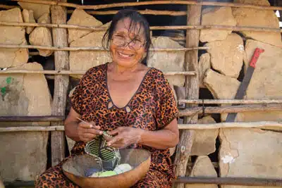 Artisan Cristina Uriana doing some weaving with a bowl of yarn