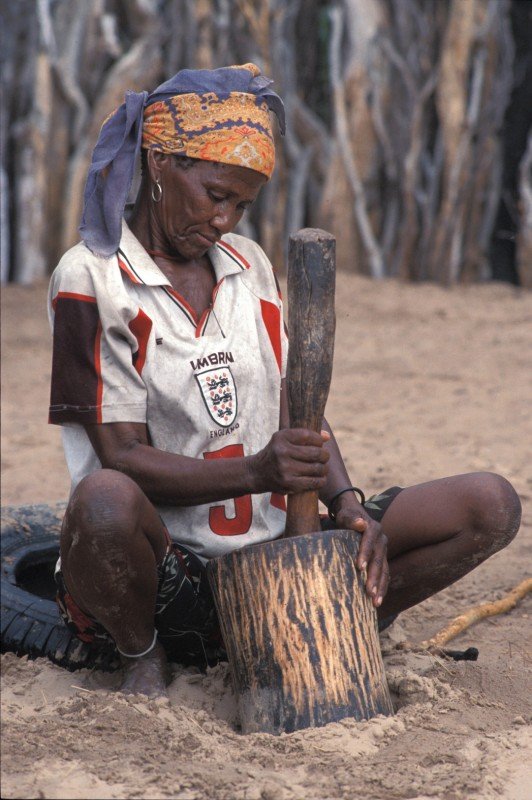 Bushman woman in the Kalahari Game Reserve grinding melon seeds for soup. Photo: Survival International