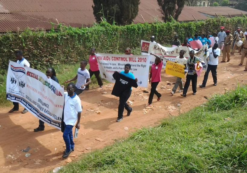 Une marche de soutien aux réfugiés, regroupant des organisations de défense des droits humains ougandaises, en 2013. On peut apercevoir la banderole de Sexual Minorities Uganda (SMUG), à gauche, qui dénonce la violence sexuelle et sexiste à l'égard des réfugiés. On estime qu'environ 400 000 réfugiés vivent en Ouganda.