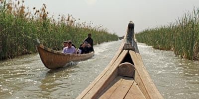 A canoe travels through the marshes in the south of Iraq. Photographed by Mohammed Alsoufi.