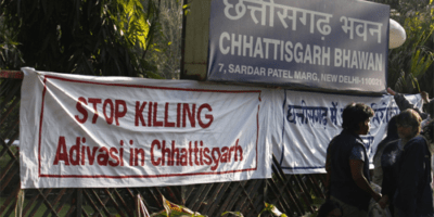 Protest banner Stop killing Adivasis