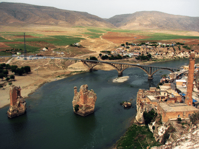 Photo of Hasankeyf with old bridge ruins in the river.