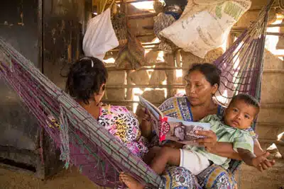 Mama Tierra artisans with book and child