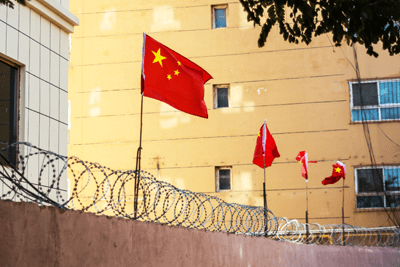 Chinese flag on wall with barbed wire